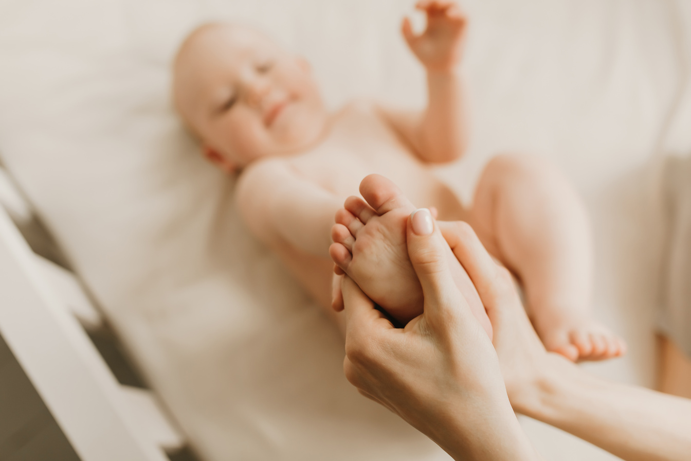 Mother and her cute baby on the bed, baby massage